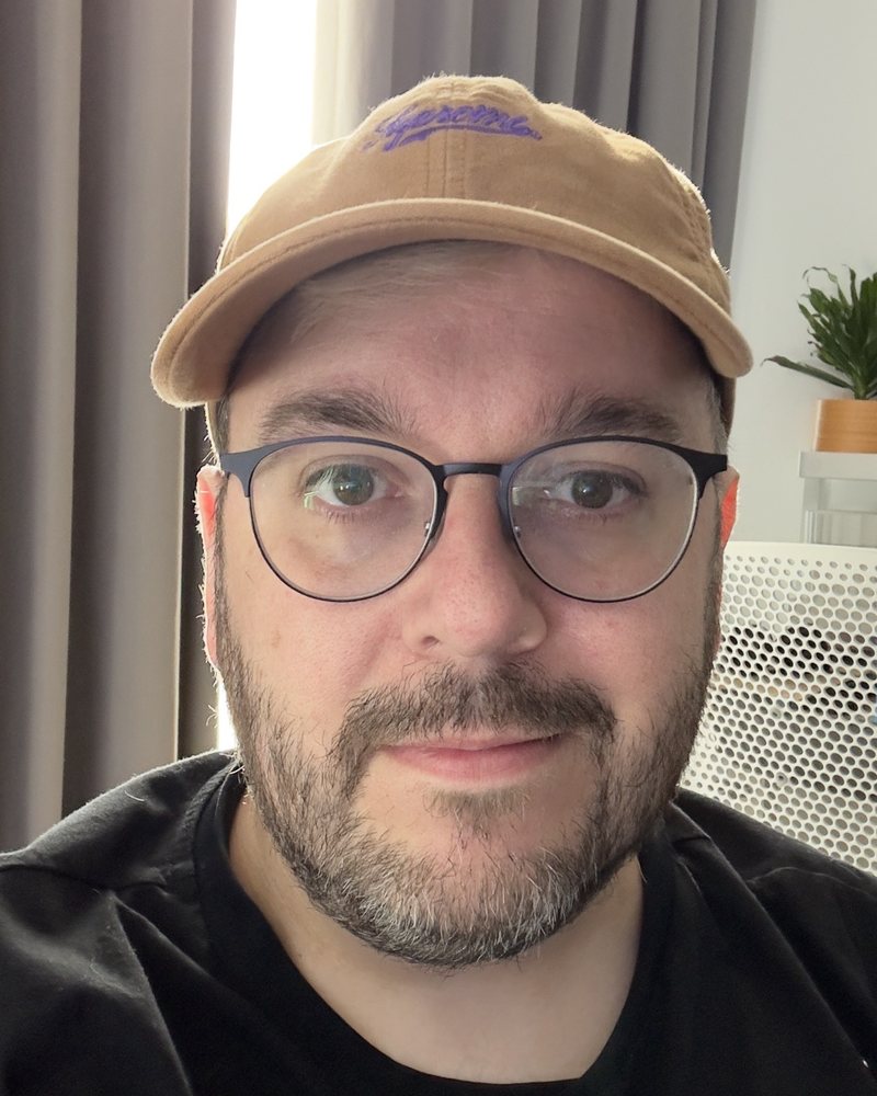 Andrew Jones, wearing a tan cap and glasses